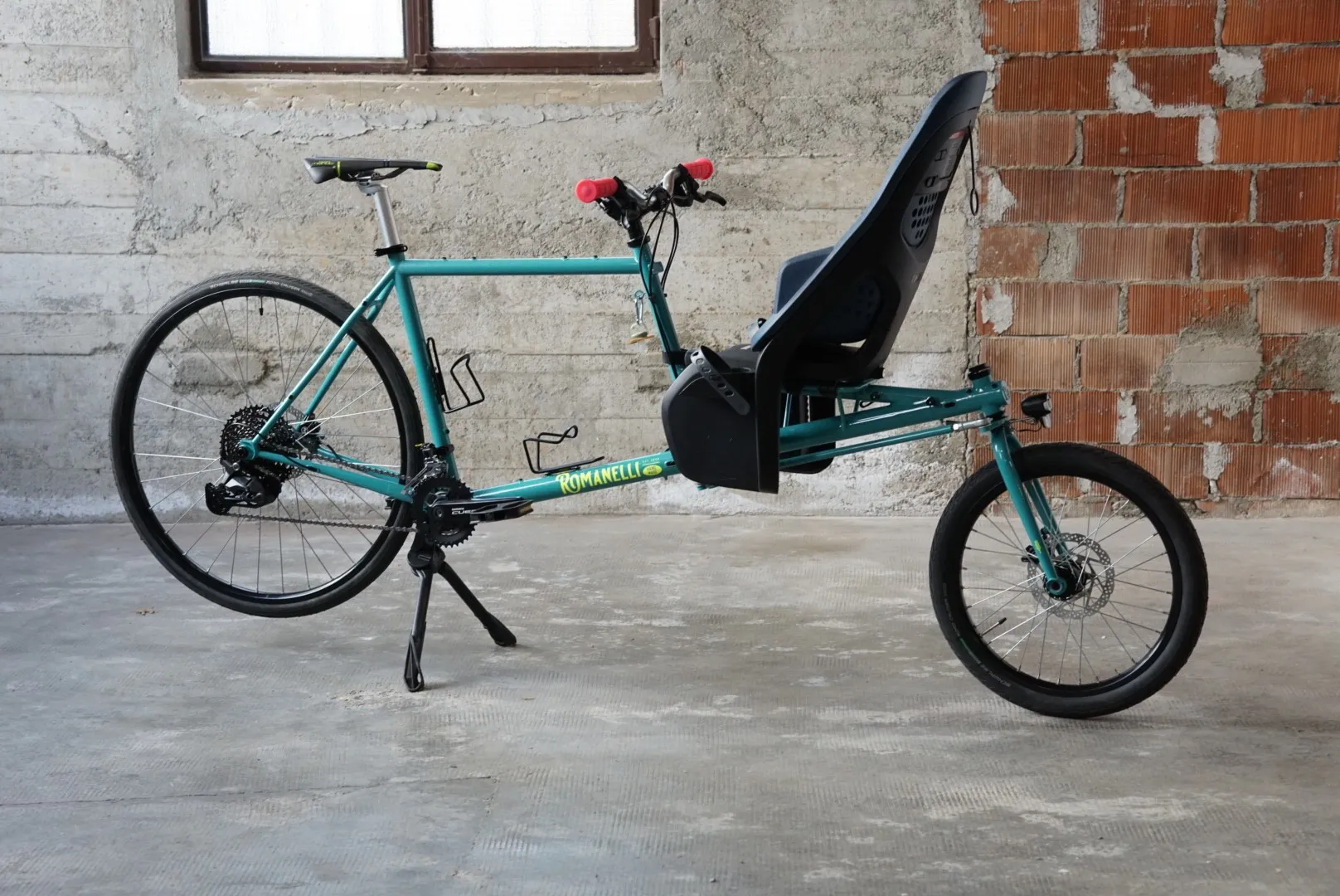 Bicicletta cargo in acciaio turchese con seduta anteriore, vista laterale — Romanelli Cicli Cargo Evolve